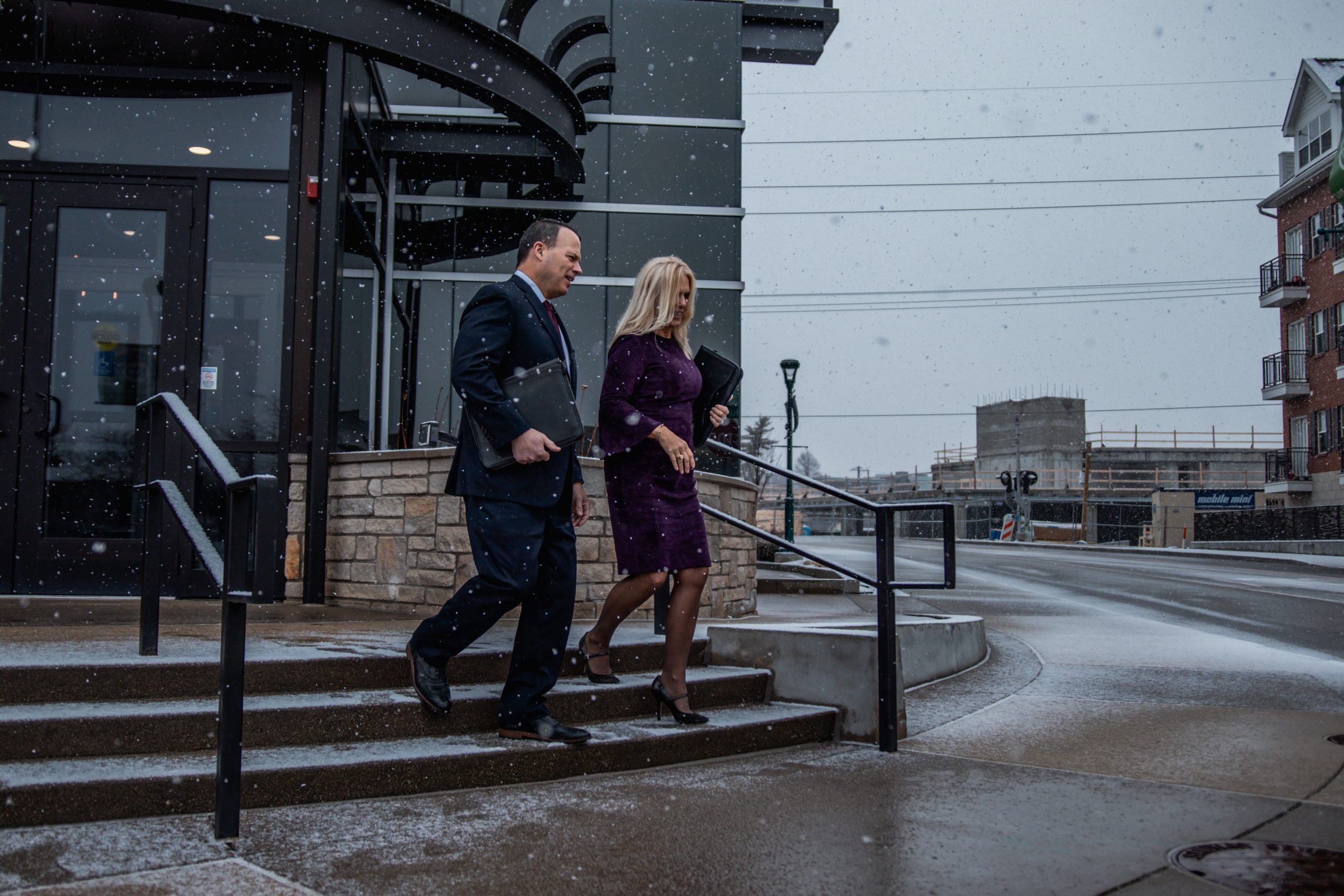 Couple Exiting Building on Stairs Corporate Travel Service by Avant Garde Limousines & Coach