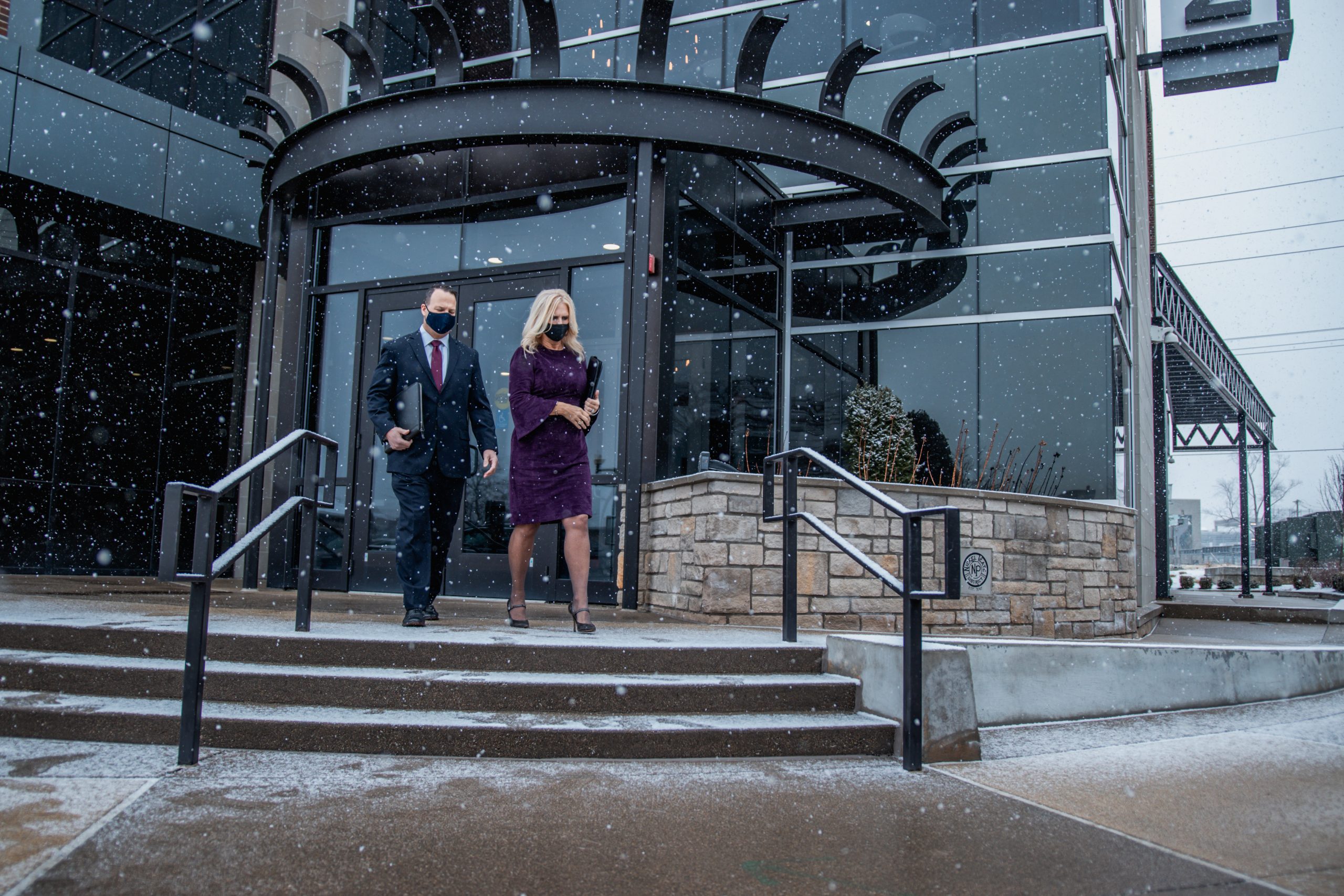Couple Exiting Building Corporate Travel Service by Avant Garde Limousines & Coach